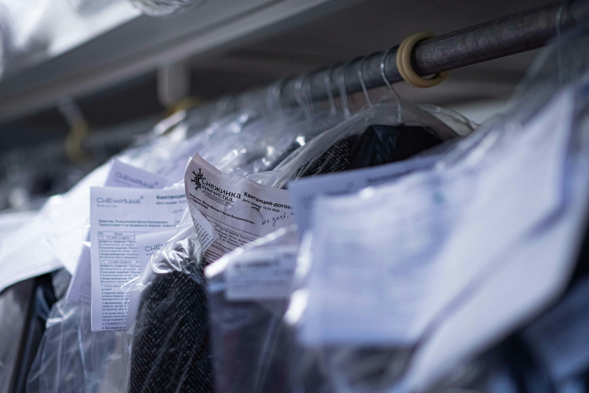 Garment inspection workflow in a textile facility, showing tracked clothing items with identification tags for quality control.